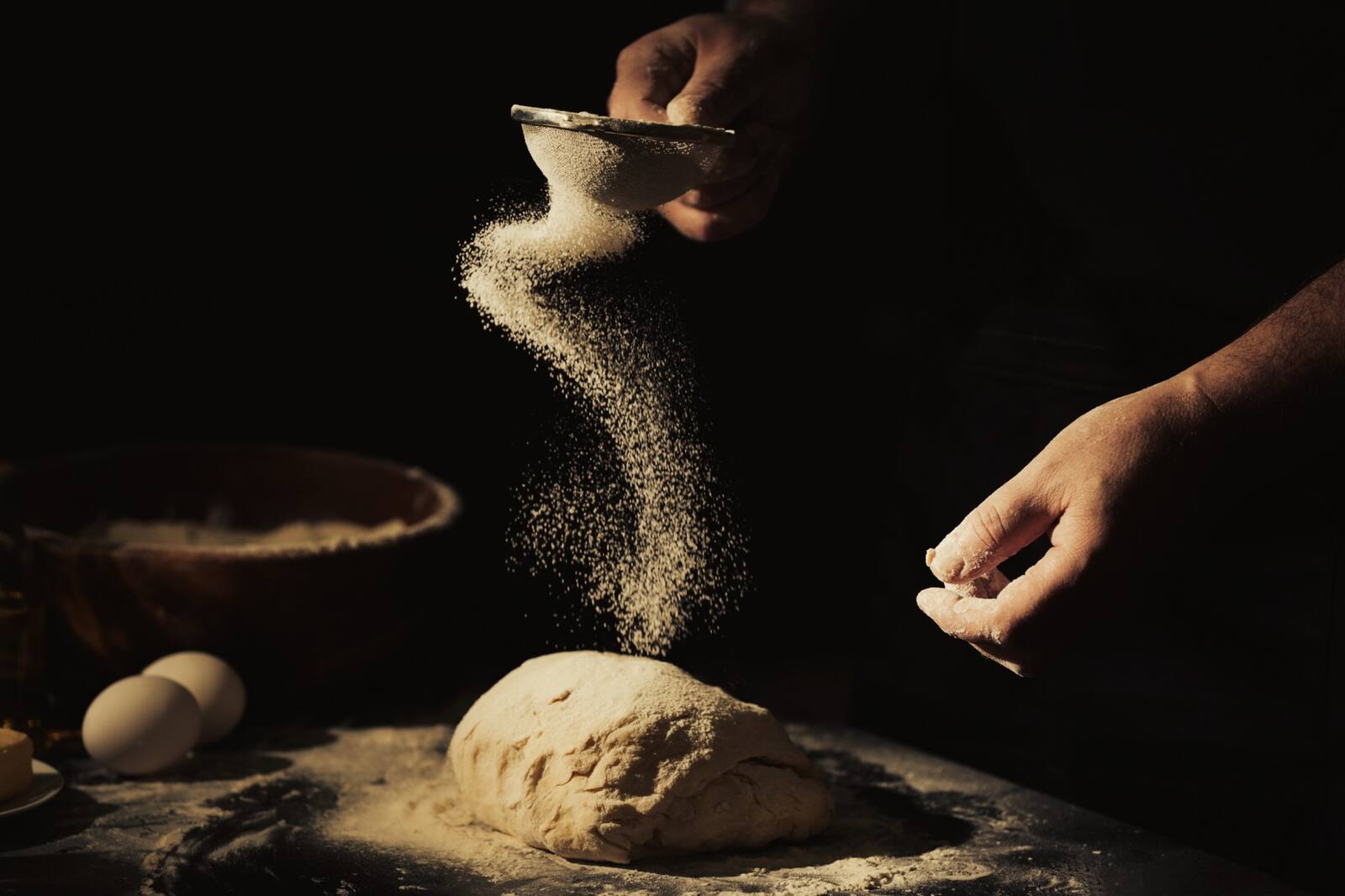 Farina setacciata sull'impasto della pasta all'uovo, con le uova